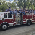 Boys football team on a fire engine in homecoming parade